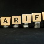 Increase tariff tax concept. Word in wooden blocks with increasing stack of coins.