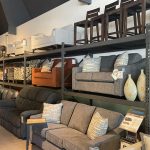Stacked furniture inventory in a furniture store. Featuring chairs and sofas.