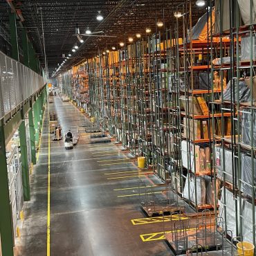 Furniture warehouse with racking and rows of furniture.